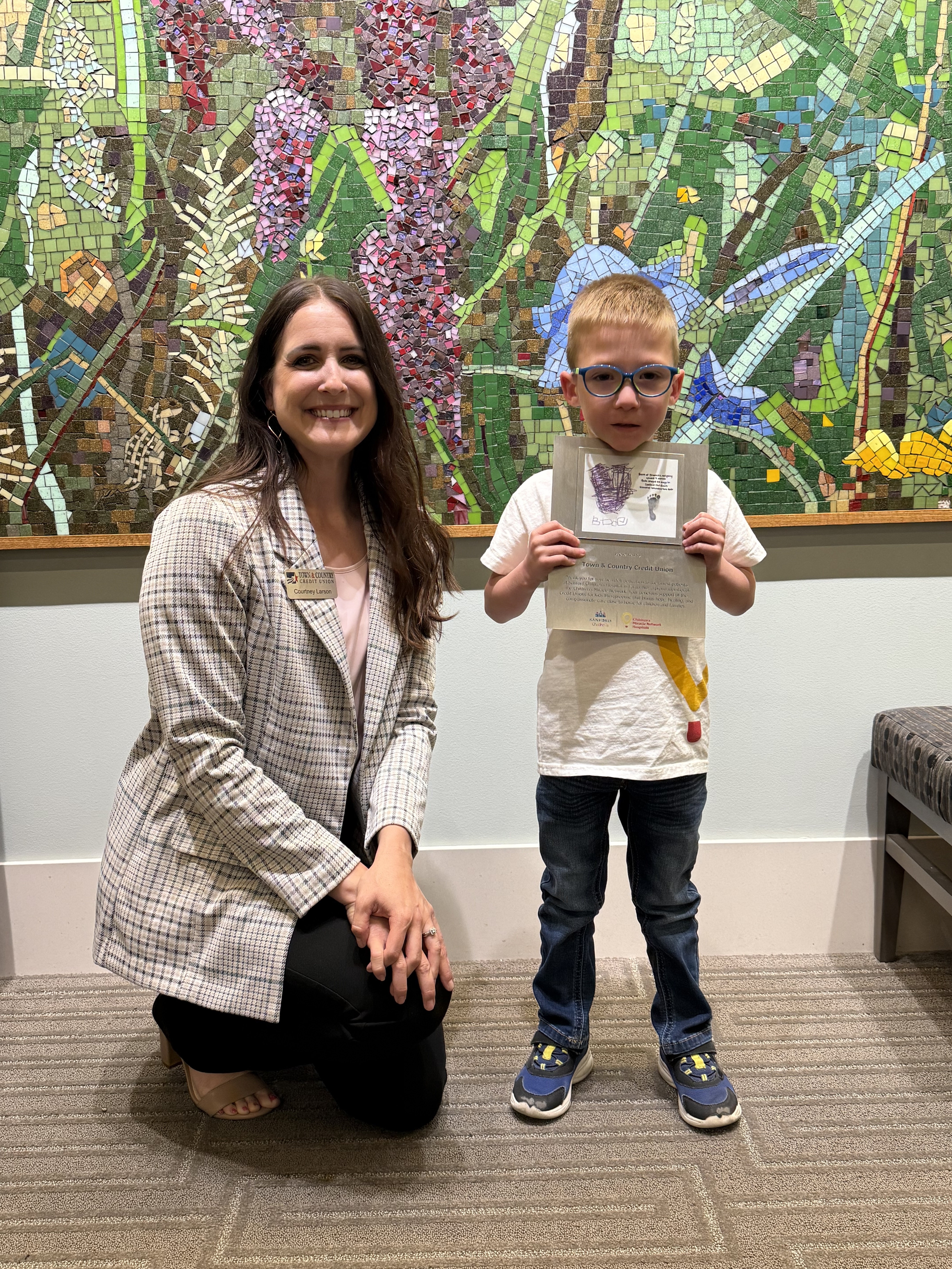 TCCU Senior Marketing Specialist Courtney Larson and Bode, a former Sanford NICU baby posing for photo.
