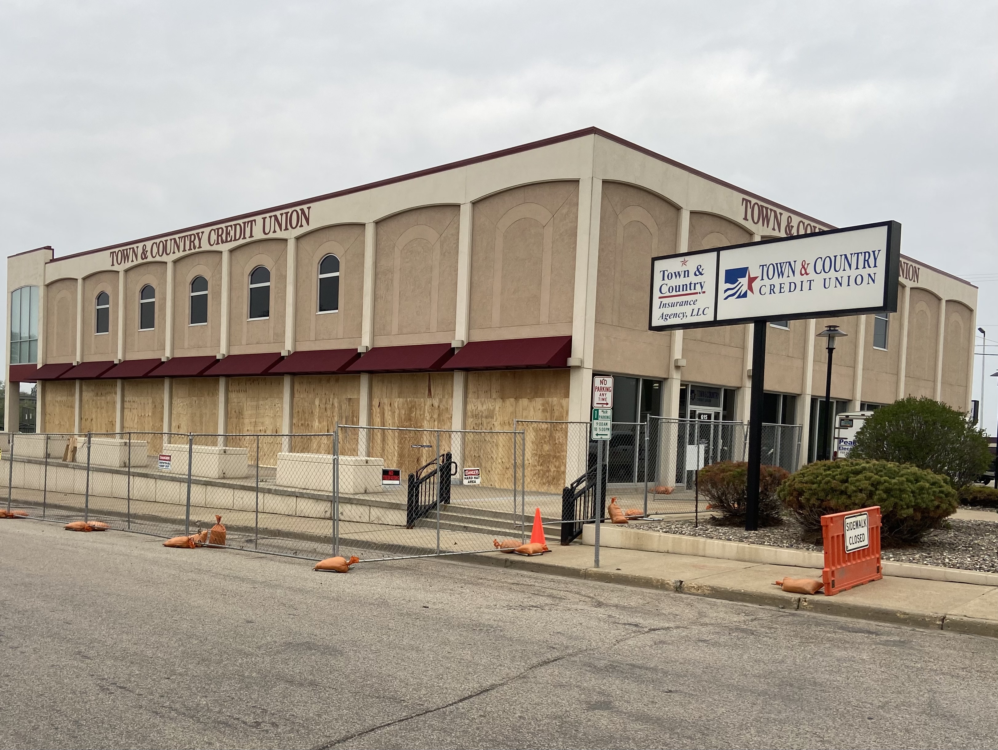 Outdoor photo of the Minot Main office with a construction fence around the building.