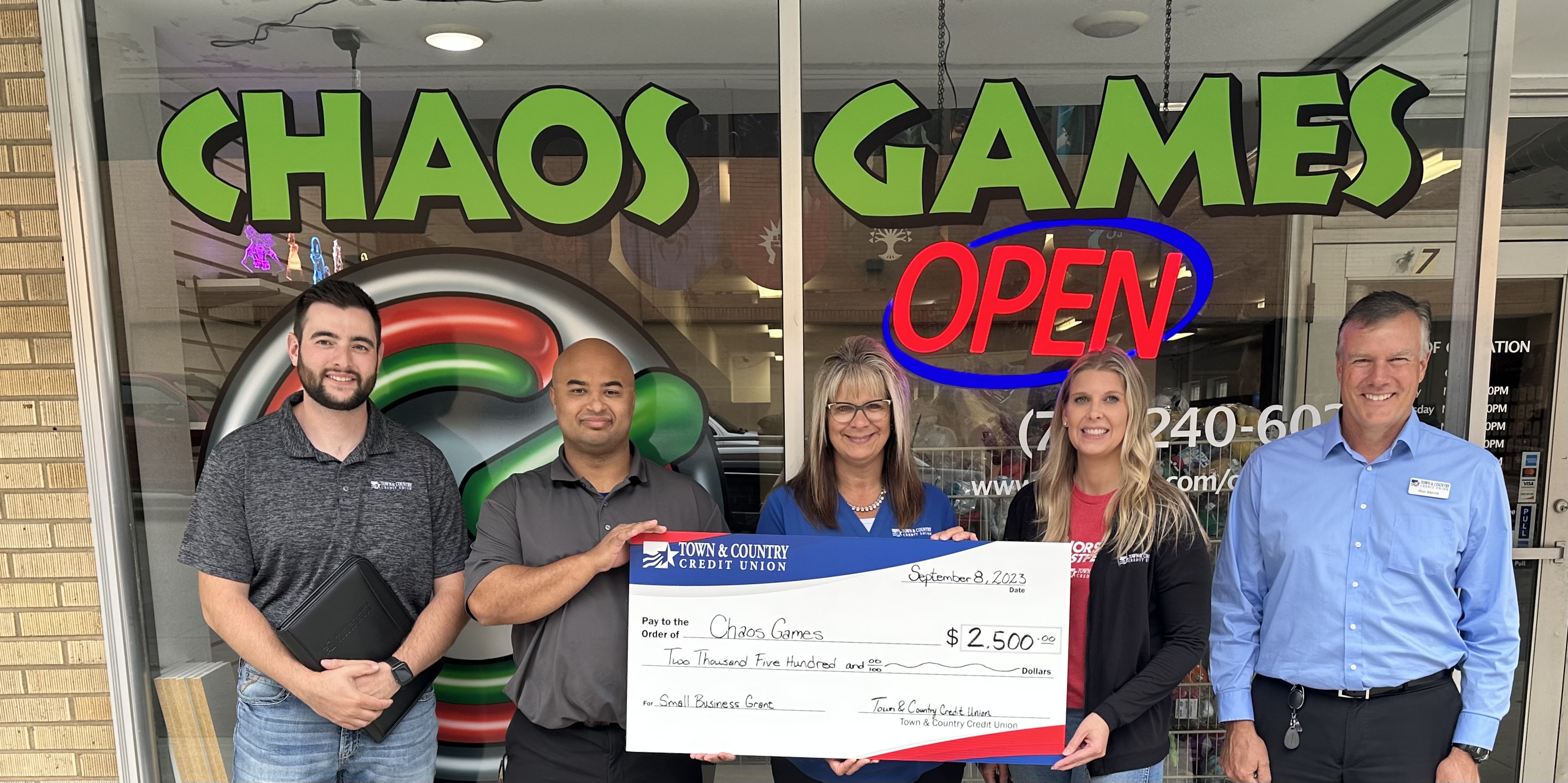 Chaos Games accepts a small business grant check